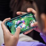Mobile gaming on a smartphone representing Mobile Legends Bang Bang 10th Anniversary skins and rewards