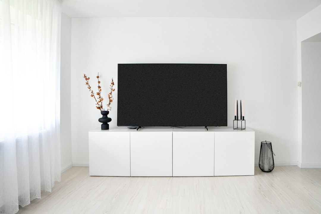 Modern Australian-style living room with a large television and media console, illustrating a smart home setup
