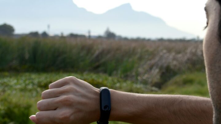 Person checking a fitness tracker, illustrating the reported Google Fitbit Edge wearable