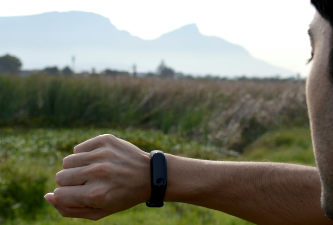 Person checking a fitness tracker, illustrating the reported Google Fitbit Edge wearable