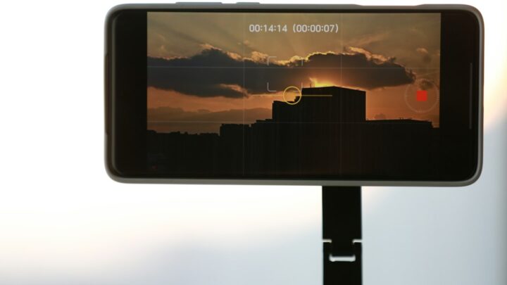 Smartphone filming a sunset scene, illustrating mobile phone filmmaking versus traditional cinema cameras
